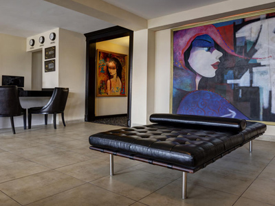 Picture of the lobby of the Costa Rica Medical Center Inn, San Jose, Costa Rica.  The picture shows a spacious interior and large picture on the wall.