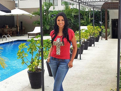 Picture of a guest wearing a red shirt and blue jeans, standing beside the pool at the Costa Rica Medical Center Inn, San Jose, Costa Rica.