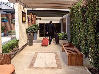 Picture of a walkway and a porter delivering luggage to a room at the Costa Rica Medical Center Inn, San Jose, Costa Rica.