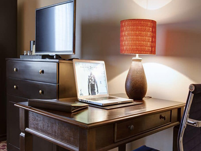 Picture of a table, chair, lamp and TV at the Costa Rica Medical Center Inn, San Jose, Costa Rica.  The picture shows the interior of a Jr. Suite.