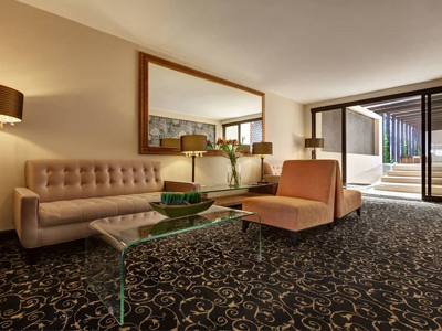 29-	Picture of a lounge area at the Costa Rica Medical Center Inn, San Jose, Costa Rica.  The picture shows a beige color scheme and a spacious interior.