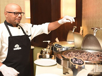 Picture of food being prepared at the Costa Rica Medical Center Inn, San Jose, Costa Rica.  The picture shows a chef overlooking the food service.