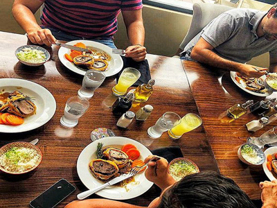 Picture of guests eating dinner at the Costa Rica Medical Center Inn, San Jose, Costa Rica.  The picture shows lavish food spread across a large table.